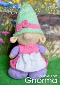 Gnorma the Gnome knitting pattern. Cream-colored knitted toy gnome approximately 30cm tall, featuring a lilac dress, pink apron, and light green hat, embodying a whimsical garden theme.