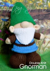 Gnorman the Gnome knitting pattern. Cream-colored knitted toy gnome approximately 30cm tall, featuring a brown outfit, blue trousers, green hat, and a white beard, embodying a whimsical garden theme.