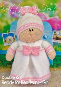 Ready for Bed Twin Girl knitting pattern. Cream-colored knitted toy doll approximately 28cm tall, dressed in a pink nightie and hat, embodying a bedtime theme.