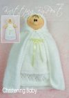 Christening Baby Doll knitting pattern. Cream-colored knitted toy doll approximately 23cm tall, dressed in a traditional white christening gown and shawl, symbolizing a significant life event.
