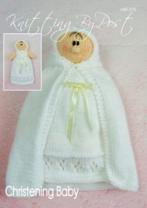 Christening Baby Doll knitting pattern. Cream-colored knitted toy doll approximately 23cm tall, dressed in a traditional white christening gown and shawl, symbolizing a significant life event.