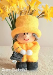 Queen Elizabeth II toy knitting pattern. Cream-colored knitted toy doll approximately 25cm tall, featuring a yellow coat and hat, grey hair, and holding a black handbag