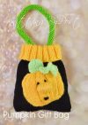 Pumpkin Gift Bag knitting pattern. Knitted black bag with an orange pumpkin face design and green leaf accents, approximately 15cm tall and 12cm wide, excluding the handle.