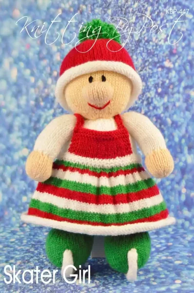 Skater Girl knitting pattern. Winter-themed knitted toy doll approximately 28cm tall, featuring a white outfit with red accents and ice skates, ready for the skating season.