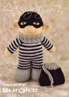 Burglar Bill knitting pattern. Cream-colored knitted toy doll approximately 28cm tall, dressed in black and white striped attire with a black mask and hat, embodying a playful burglar character.