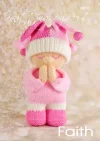 Faith the Dolly knitting pattern. Cream-colored knitted toy doll approximately 27cm tall, featuring a peaceful pose with hands clasped in prayer, wearing a pink outfit and hat.