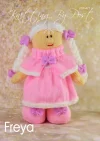 Freya the Dolly knitting pattern. Pink knitted toy doll approximately 35cm tall, featuring removable clothes, a round head with stitched facial features, and lilac accents.