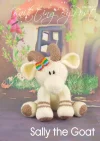 ​Sally the Goat toy knitting pattern. Knitted cream-colored goat with brown hooves and inner ears, adorned with a rainbow-colored ribbon between the horns, approximately 26cm tall.