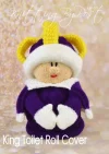 Royal King toy knitting pattern. Knitted figure representing a king, wearing a yellow crown, purple robe with white trim, and red shoes, designed as a toilet roll cover, approximately 25cm tall.