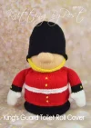 King's Guard toy knitting pattern. Knitted figure representing a King's Guard, wearing a red tunic, black hat, and white belt, designed as a toilet roll cover, approximately 24cm tall.
