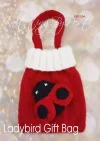 Ladybird Gift Bag knitting pattern. Easter-themed knitted bag approximately 15cm tall and 12cm wide, featuring a red body with black spots and a white top edge, perfect for holding small treats or gifts.