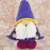 Short and Sweet Wizard knitting pattern. Purple knitted toy wizard approximately 27cm tall, featuring a tall pointed hat, long white beard, and yellow accents.