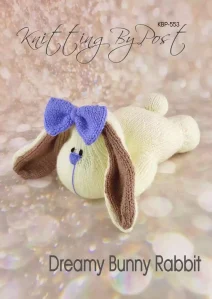 Dreamy Bunny Rabbit knitting pattern. Cream-colored knitted toy rabbit approximately 26cm long, featuring brown ears, a purple nose, and a relaxed, lying-down posture.