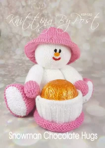 Snowman Chocolate Hugs knitting pattern. Christmas-themed knitted toy snowman approximately 18cm tall when seated, designed to hold a chocolate orange within a pot. Features a white body, pink accents, and a festive hat.