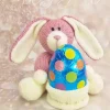 Bunny Rabbit Chocolate Egg Hugs knitting pattern. Easter-themed knitted toy bunny approximately 18cm tall, featuring a pink body, cream-colored ears, paws, and feet, holding a small knitted cream pot designed to contain a chocolate egg