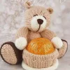 Hand-knitted brown bear holding a chocolate treat, made using the Bear Chocolate Hugs knitting pattern.